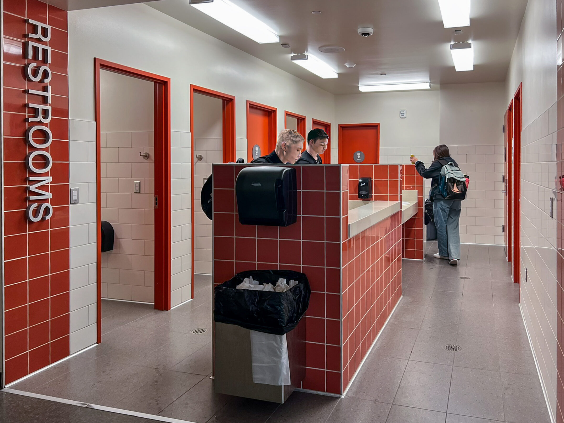 Single‑user restrooms at Graham‑Kapowsin High School are located off a main hallway in one wing, integrating universal access into daily student movement. Photo by NAC Architecture. Student figures shown have been altered for privacy and do not represent actual students.